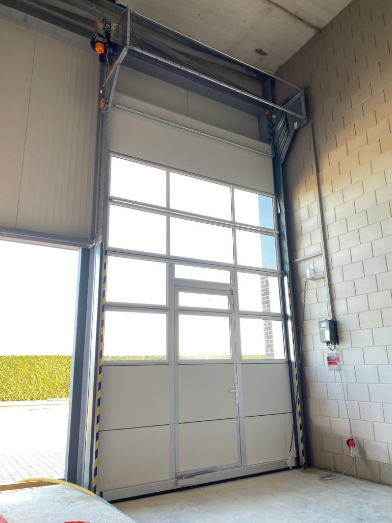 Wicket door in a sectional door with glass panels